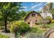 Charming stone and wood home featuring a unique barn-style architecture, a picket fence, and mature trees at 8324 Humie Olive Rd, Apex, NC 27502