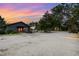 Expansive property features multiple buildings, a gravel driveway, mature trees, and lush landscaping at 8324 Humie Olive Rd, Apex, NC 27502