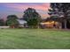This sprawling property features multiple barns and a house surrounded by lush green grass and mature trees at 8324 Humie Olive Rd, Apex, NC 27502