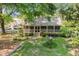 Charming cottage with a screened front porch, beautiful landscaping, stone walkway, and mature trees at 8324 Humie Olive Rd, Apex, NC 27502