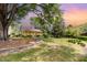 Charming home with covered porch, stone wall feature, and mature trees in a spacious front yard at 8324 Humie Olive Rd, Apex, NC 27502