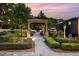 Beautiful stone garden pathway leading to a shaded gazebo, surrounded by lush greenery and manicured landscaping at 8324 Humie Olive Rd, Apex, NC 27502
