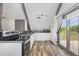 Galley kitchen featuring stainless appliances, a tile backsplash, and an outside deck through a sliding glass door at 8324 Humie Olive Rd, Apex, NC 27502
