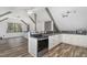 Modern kitchen featuring stainless steel appliances, white cabinets, and an open layout with hardwood floors at 8324 Humie Olive Rd, Apex, NC 27502