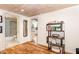 Comfortable living room featuring wood floors, decorative shelving, and access to the bathroom and kitchen at 8324 Humie Olive Rd, Apex, NC 27502