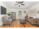 Inviting living room features hardwood floors, a ceiling fan, and a comfortable seating area with a sofa and armchair at 8324 Humie Olive Rd, Apex, NC 27502
