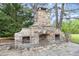 Outdoor stone fireplace with wood storage and a seating area, perfect for gatherings at 8324 Humie Olive Rd, Apex, NC 27502