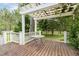 Charming patio area with a pergola and views of the well-maintained yard and surrounding greenery at 8324 Humie Olive Rd, Apex, NC 27502