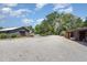 Wide property view showing home, barn, gravel drive, parking area and shade trees at 8324 Humie Olive Rd, Apex, NC 27502