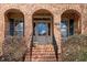 Inviting front entrance with brick steps and decorative plants, showcasing the home's curb appeal at 8912 Riverview Park Dr, Raleigh, NC 27613