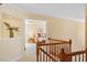 Upstairs hallway view leads to bedroom with neutral decor and furnishings at 8912 Riverview Park Dr, Raleigh, NC 27613
