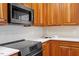 Modern kitchen featuring granite countertops and stainless steel appliances including built-in microwave at 8912 Riverview Park Dr, Raleigh, NC 27613