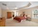 Bright main bedroom with tray ceiling and windows featuring a queen size bed at 8912 Riverview Park Dr, Raleigh, NC 27613