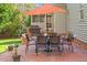 Charming brick patio features an outdoor dining set and a patio umbrella at 8912 Riverview Park Dr, Raleigh, NC 27613