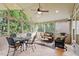 Relaxing screened-in sunroom featuring tiled flooring, wicker furniture, and a ceiling fan at 8912 Riverview Park Dr, Raleigh, NC 27613