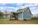 Home's backyard shows a screened-in porch, siding, and greenery under a partly cloudy sky at 100 E Delafield Ave, Durham, NC 27704
