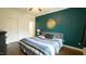 Stylish bedroom with wood panel accent wall, wood flooring, and a comfortable queen bed at 100 E Delafield Ave, Durham, NC 27704