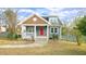 Charming home featuring a red front door, blue siding, and a cozy, covered front porch at 100 E Delafield Ave, Durham, NC 27704