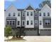 Modern townhome showcasing a three-story facade, gray and white siding, and individual garages at 1013 Regalia Rd # 28, Durham, NC 27713