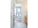 Modern bathroom featuring white penny tile, wood vanity, and a view to the bedroom at 103 Inara Ct, Carrboro, NC 27510