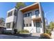 Modern two-story home with a combination of white siding and grey metal, complemented by clean landscaping and a patterned driveway at 103 Inara Ct, Carrboro, NC 27510