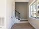 Bright foyer featuring hardwood floors, a staircase with metal railings, and a large window providing natural light at 103 Inara Ct, Carrboro, NC 27510