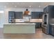 Open concept kitchen with a large island, stainless steel appliances, and modern cabinetry with copper hardware at 103 Inara Ct, Carrboro, NC 27510