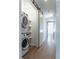 Efficient laundry area with stacked washer/dryer and storage shelves behind a sliding barn door at 103 Inara Ct, Carrboro, NC 27510