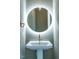 Charming powder room with illuminated round mirror, pedestal sink and copper fixtures at 103 Inara Ct, Carrboro, NC 27510