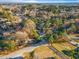 Expansive aerial view of a residential neighborhood featuring mature trees and well-maintained homes under a clear blue sky at 109 Hardee St, Clayton, NC 27520