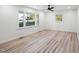 Bright bedroom boasts new flooring, a ceiling fan, and natural light from many windows at 109 Hardee St, Clayton, NC 27520