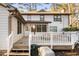 Backyard view of home featuring a white deck and exterior lighting at 1201 Deerfield Dr, Cary, NC 27511