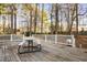 Spacious deck surrounded by trees featuring a table for outdoor dining and entertaining at 1201 Deerfield Dr, Cary, NC 27511