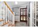 Welcoming foyer with hardwood stairs, grey walls, and a glass front door for a bright entrance at 1201 Deerfield Dr, Cary, NC 27511