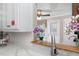 Close up of kitchen with white marble counters, view of backyard and stainless steel sink at 1201 Deerfield Dr, Cary, NC 27511