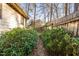 Side yard features manicured shrubs, a stone pathway, and a wood fence at 1201 Deerfield Dr, Cary, NC 27511