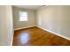 A bright bedroom with hardwood flooring and a window allowing for natural light at 128 Barclay Rd, Durham, NC 27712