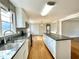 Charming kitchen with white cabinets, granite counters and stainless appliances open to the living area at 128 Barclay Rd, Durham, NC 27712
