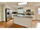 Bright kitchen with white cabinets, stainless appliances, granite countertops and hardwood flooring at 128 Barclay Rd, Durham, NC 27712