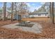 Backyard featuring a brick-lined seating area and a fire pit, surrounded by natural foliage at 129 Shawnee Dr, Louisburg, NC 27549