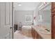 A tiled bathroom featuring dual sinks, modern fixtures, and a corner tub at 129 Shawnee Dr, Louisburg, NC 27549
