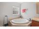 Bright bathroom featuring a large soaking tub and glass block window for natural light at 129 Shawnee Dr, Louisburg, NC 27549