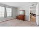 A carpeted bedroom with two large windows and a traditional dresser with a mirror at 129 Shawnee Dr, Louisburg, NC 27549
