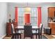 Dining room featuring dark wood table, modern chairs, and view of landscaped outdoors at 129 Shawnee Dr, Louisburg, NC 27549