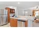 Kitchen featuring a stainless-steel refrigerator, a sink, and breakfast bar overlooking the living area at 129 Shawnee Dr, Louisburg, NC 27549