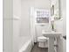 Bright bathroom featuring a shower-tub combination, pedestal sink, and a window providing natural light at 1304 N Duke St, Durham, NC 27701