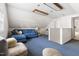 Spacious bonus room with bright blue carpet and a comfortable blue couch at 1304 N Duke St, Durham, NC 27701