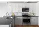 Updated kitchen features modern appliances, light gray cabinets, and a granite countertop at 1304 N Duke St, Durham, NC 27701