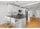 Bright and updated kitchen features seating at the island, modern appliances, and a view to the living area at 1304 N Duke St, Durham, NC 27701