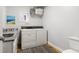 Functional laundry room with a washer, dryer, utility sink, and overhead shelving at 1304 N Duke St, Durham, NC 27701